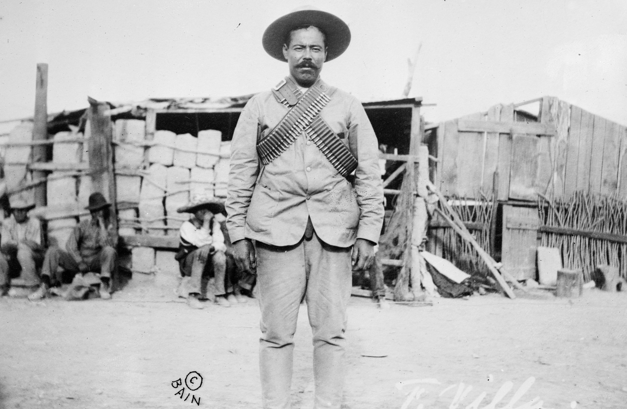 Villa wearing bandoliers in front of an insurgent camp 